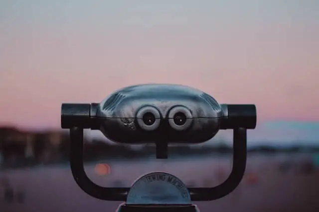 A set of binoculars with scenery in the background.